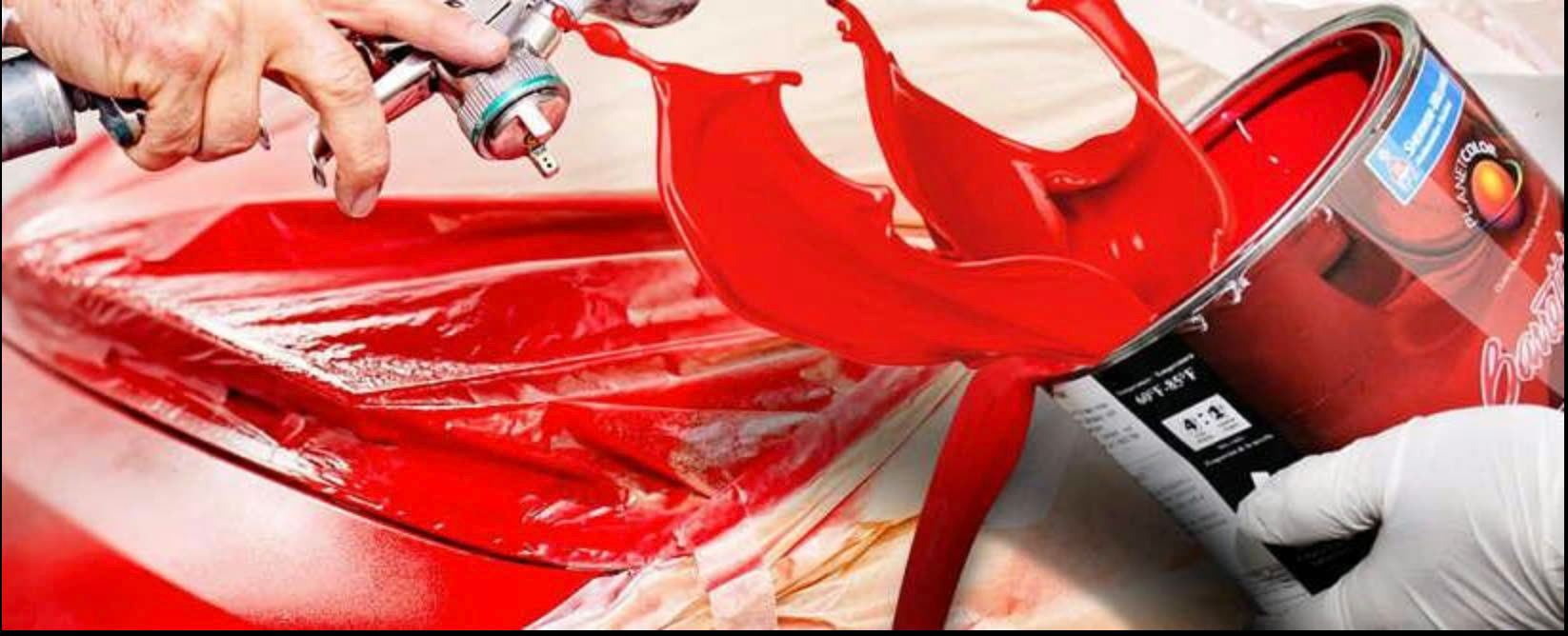 Spray gun applying bold red paint to a custom vehicle panel, with paint flowing dramatically